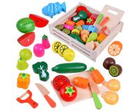 Fából készült vágható zöldségek és gyümölcsök ládában, késekkel és vágódeszkával